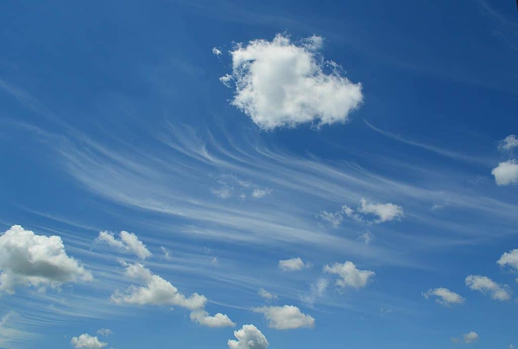 A picturesque clear blue sky with scattered fluffy clouds creating a serene atmosphere.